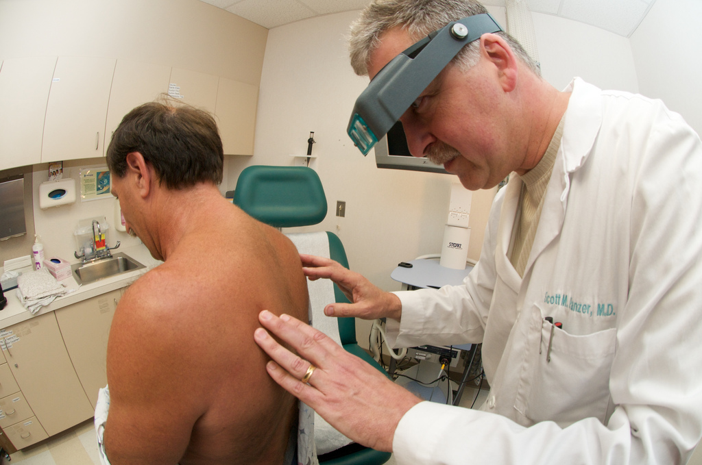 дерматолог осматривает кожные покровы